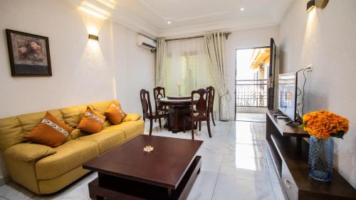 uma sala de estar com um sofá e uma mesa em Residence Le Bonheur - Serviced apartment by Douala Airport/Mall em Douala