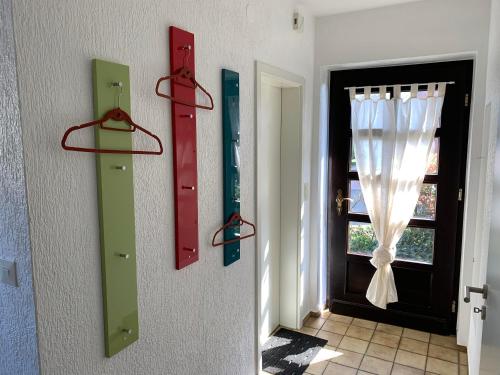 een hal met rode en groene deuren en een raam bij Ferienhaus Wacholderhain in Haselünne