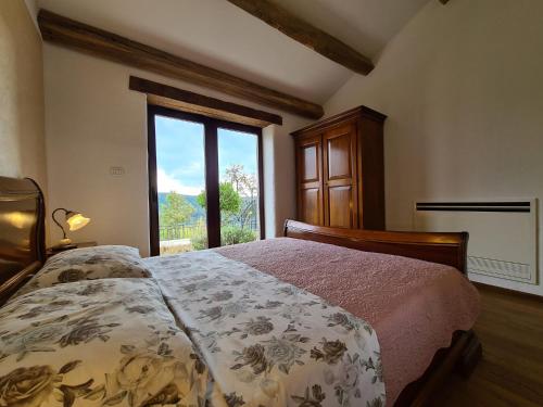 ein Schlafzimmer mit einem Bett und einem großen Fenster in der Unterkunft Villa Motovun 2129 in Bartolići