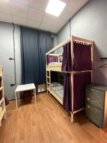 a room with a bunk bed with purple curtains at Good Night rooms & hostel in Murmansk