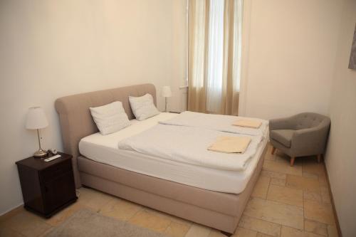 sypialnia z dużym łóżkiem i krzesłem w obiekcie Heart of Vienna - City Apartment w Wiedniu