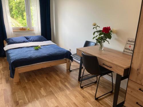 sypialnia z łóżkiem, biurkiem i stołem w obiekcie Apartament KR-P Nad Jeziorem Ostróda Villa Park w Ostródzie