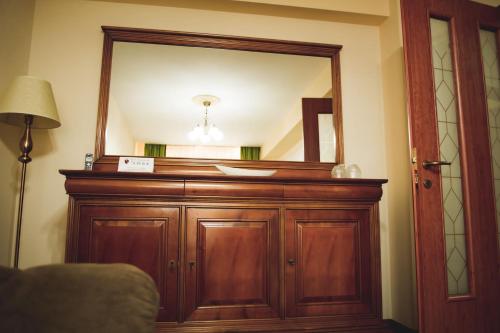 a mirror on top of a wooden cabinet in a room at Hotel Senator in Slatina
