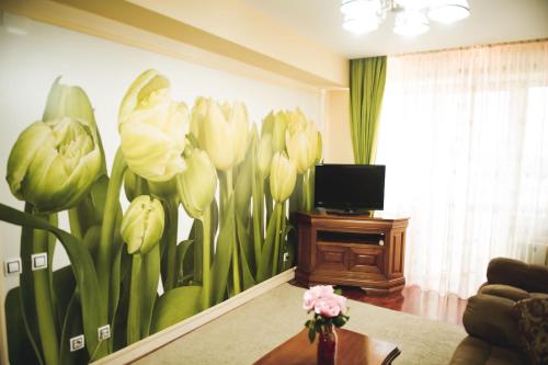 a living room with a painting of flowers on the wall at Hotel Senator in Slatina
