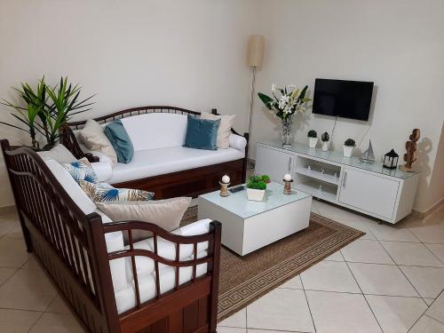 un soggiorno con divano e TV di Lindo Apartamento Beira-mar - Ubatuba-SP a Ubatuba