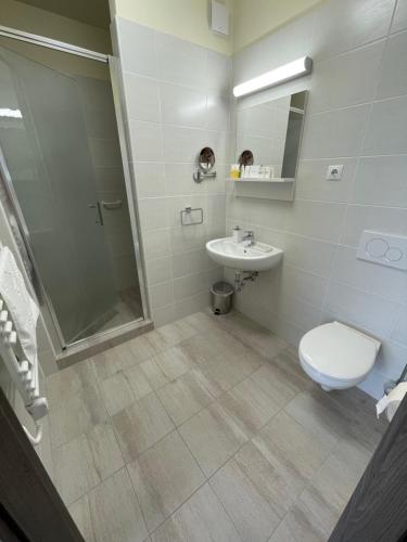 e bagno con servizi igienici, lavandino e doccia. di Gyirmót Sport & Wellness Hotel a Győr