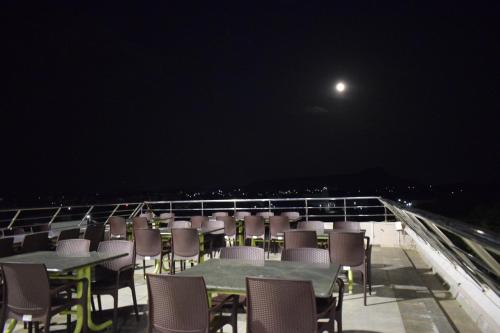 a group of tables and chairs on a balcony at night at Hotel Vijay Krishna in Madurai