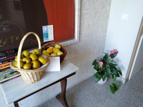 a basket of fruit on a table next to a window at Apartamentos MonteBlanco Costa da Morte in Neaño