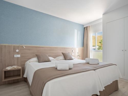Кровать или кровати в номере Puerto Azul Suite Hotel