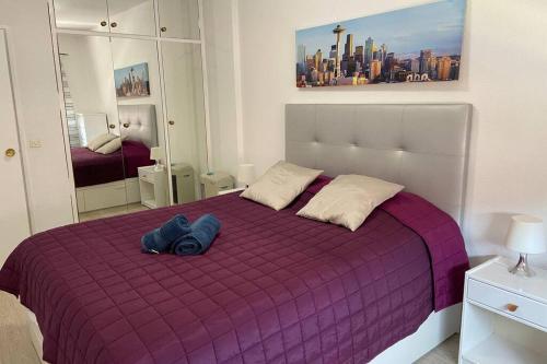 una cama morada con un par de jeans sentados en ella en Cozy and modern apartment in Maspalomas en San Fernando