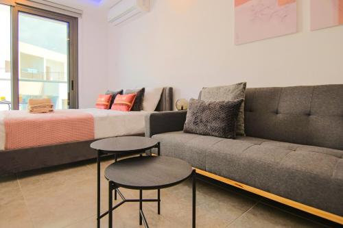 a living room with a couch and a bed at Phaedrus Living: Seaside Luxury Flat Athina 115 in Paphos City