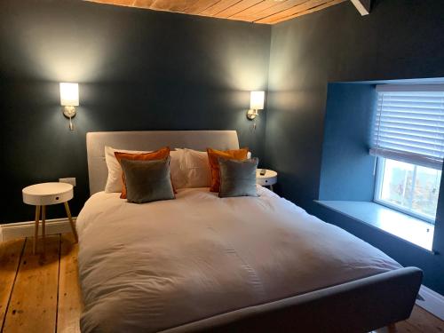 a large bed in a bedroom with a blue wall at Min-Y-Fford sleeps 6 plus pet in Newport Pembrokeshire