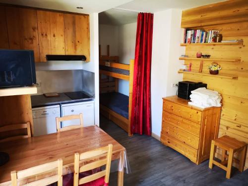 a dining room with a table and a kitchen with a bunk bed at Borsat - Beau Studio 4pax sur les pistes, avec balcon in Tignes