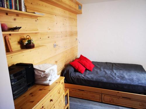 a bedroom with a bed and a wooden wall at Borsat - Beau Studio 4pax sur les pistes, avec balcon in Tignes