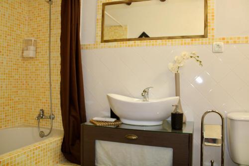 a bathroom with a sink and a tub and a mirror at A nossa Estrela in Moura