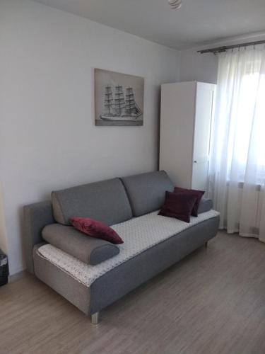 a couch in a living room with two pillows on it at Dom Mazury Harsz in Harsz