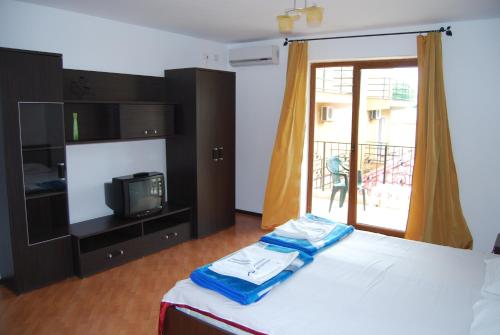 1 dormitorio con 1 cama, TV y ventana en Vila Silvia, en Eforie Sud