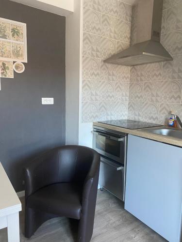 une cuisine avec une chaise noire et un évier dans l'établissement Treilles'Appart, à Lille