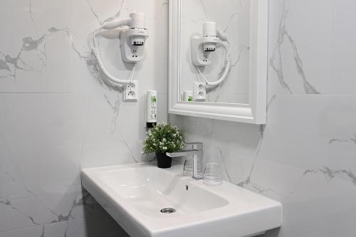 a white bathroom with a sink and a mirror at Hotel Malá Strana in Prague