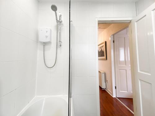 La salle de bains est pourvue d'une douche et d'une porte en verre. dans l'établissement Glasgow Green Park Home, à Glasgow