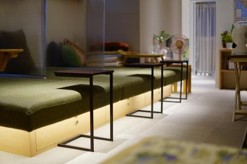 a row of beds lined up in a room at Guesthouse COCO Hiroshima (Female Only) in Hiroshima