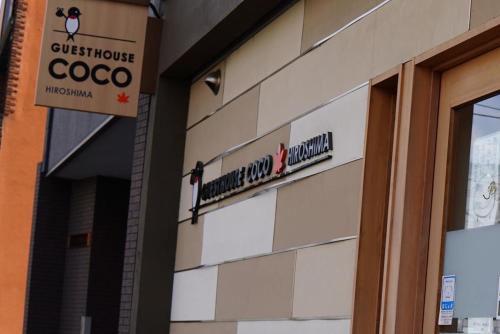 a building with a sign on the side of it at Guesthouse COCO Hiroshima (Female Only) in Hiroshima