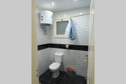 een badkamer met een toilet en een tv. bij sheraton blaza 101 in Hurghada