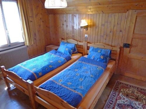 a bedroom with two beds in a wooden cabin at Heiderösli 1st Floor and Attic Apartment in Grächen
