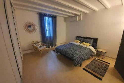 una camera da letto con un letto, una sedia e una finestra di La Montille a Arles