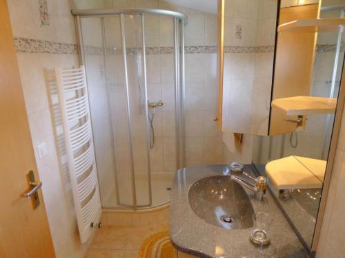 a bathroom with a sink and a shower at Heiderösli 1st Floor and Attic Apartment in Grächen