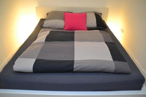 łóżko z czerwoną poduszką na górze w obiekcie Ferienwohnung "Alte Druckerei" w mieście Eisenberg