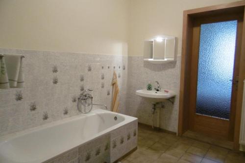 a bathroom with a bath tub and a sink at Ferienwohnung Rauscher in Kurort Altenberg