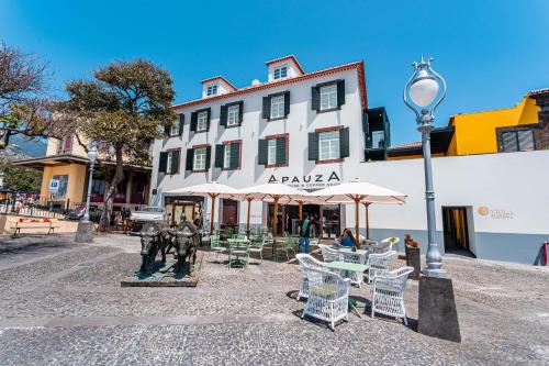 a building with tables and chairs and a street light at FLH Viola Market Flats in Funchal