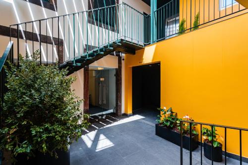 a hallway of a building with a yellow wall and stairs at FLH Viola Market Flats in Funchal
