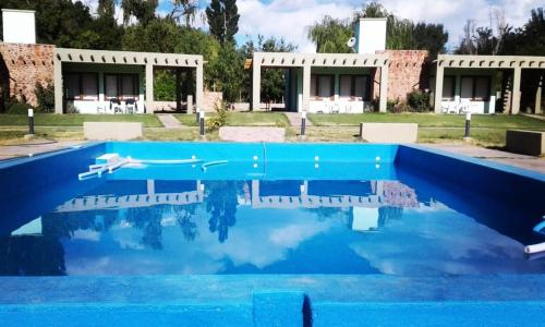 a swimmer in a pool in front of a house at COMPLEJO LOS ENAMORADOS in Calingasta