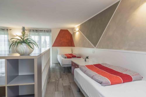 Habitación pequeña con 2 camas y escritorio. en Appartamenti Decarli, en Spormaggiore