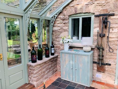 an outdoor room with wine bottles on a stone wall at Beautiful Old Water Mill in Rural Herefordshire in Hereford