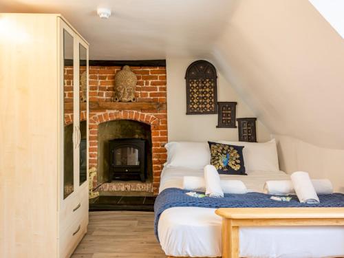 a room with a bed and a brick fireplace at Pass the Keys Renovated Apartment in the Centre of Canterbury in Canterbury