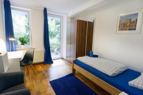 a bedroom with a bed and a desk and a window at Basement Rotherbaum in Hamburg