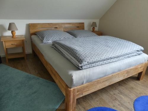 1 dormitorio con 1 cama de madera y 2 mesitas de noche en Bramwaldblick, en Hannoversch Münden