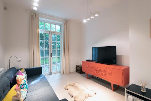 a living room with a couch and a flat screen tv at Apartment 2 The Grove in Durham