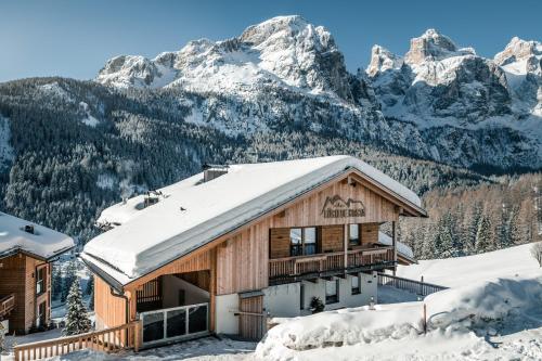 a ski lodge with snow covered mountains in the background at Lüch de Costa in Colfosco