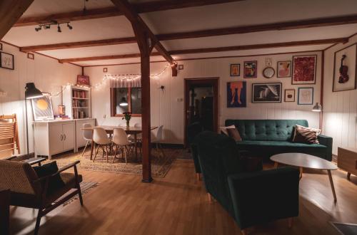 a living room with a green couch and a table at Jarzębinowa - Dom do wynajęcia na Podlasiu in Łuka