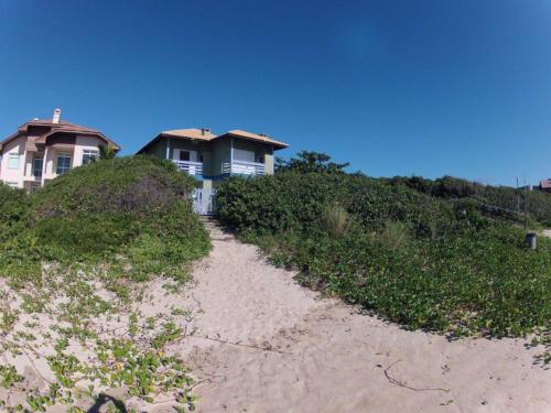 una casa en la cima de una playa con un camino de tierra en NaPraia Mariscal, en Bombinhas