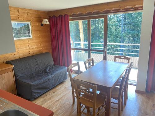 a living room with a table and a couch at apt 4/6 pers aux villages du Bachat chamrousse in Chamrousse