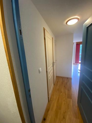 an empty room with a door and a hallway at apt 4/6 pers aux villages du Bachat chamrousse in Chamrousse