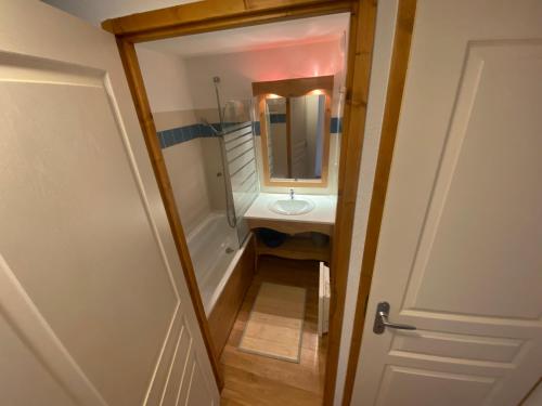 a small bathroom with a sink and a mirror at apt 4/6 pers aux villages du Bachat chamrousse in Chamrousse