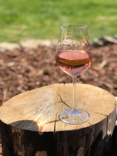 a glass of wine sitting on top of a wooden stump at B&B Le Nid d'Hirondelle in Houffalize