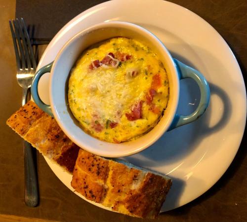 a bowl of food on a plate with some bread at B&B Le Nid d'Hirondelle in Houffalize