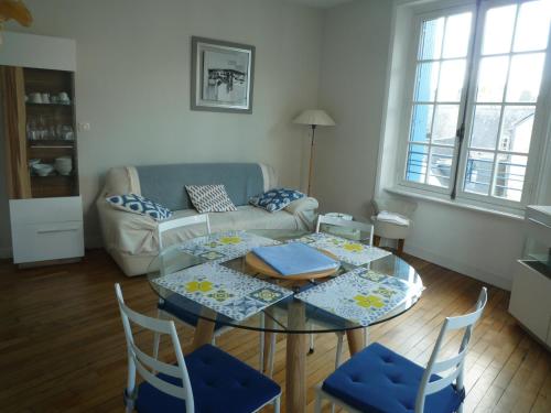 un salon avec une table, des chaises et un canapé dans l'établissement Appartement Hypercentre Quimper, à Quimper